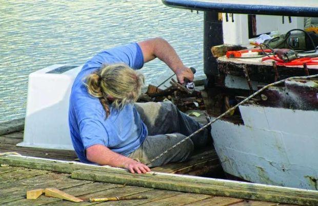Ernie Stuermer removing rotten wood from the chunk stern of the buy boat Murial Eileen at Hartge Yacht Yard in Galesville, MD.