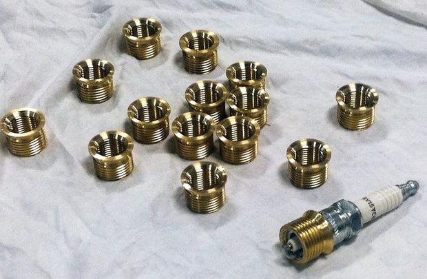 Customized bushings to allow a modern 14 MM spark plug to fit in a Barr manifold on a 1969 Ford 289 Interceptor, adapted in the machine shop at Hartge Yacht Yard in Galesville, MD.