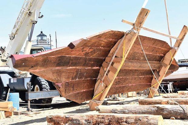 The seven-log bottom for the bugeye Edna W. Lockwood being flipped over by a crane at the Chesapeake Bay Maritime Museum in St. Michaels, MD.