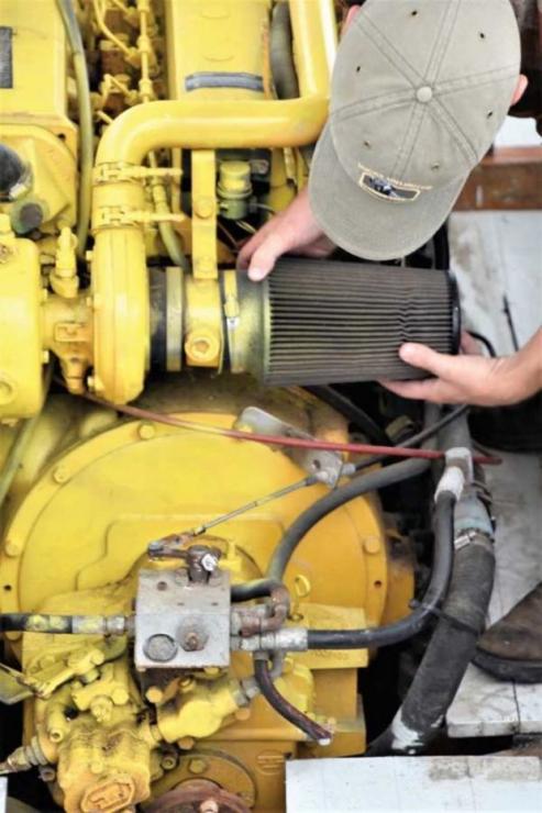 Chesapeake Bay Maritime Museum mechanic Josh Richardson removes the air filter from Dorothy Lee’s engine in the shop at St. Michaels, MD.