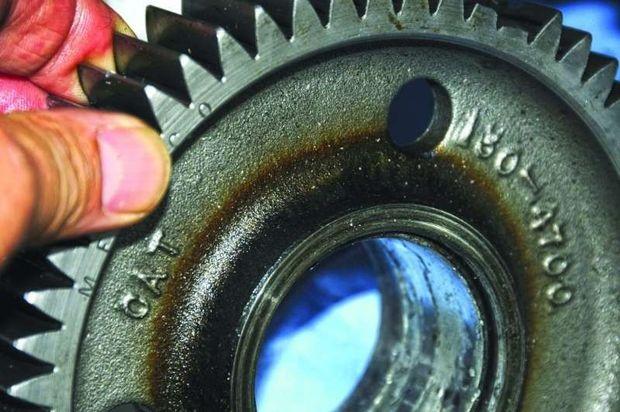 Sludge and varnish-induced lubrication starvation causes bearings to run hot, this gear is discolored from high temperature, which in turn accelerates oil degradation.