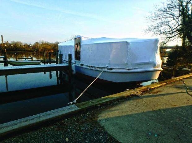 The buy boat Crow Brothers II tented for the winter at Mathews Landing on the Choptank in Denton, MD.